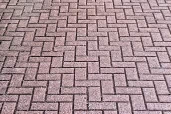 Brick A brick outdoor flooring that is made of red brick and laid in a zig zag pattern.