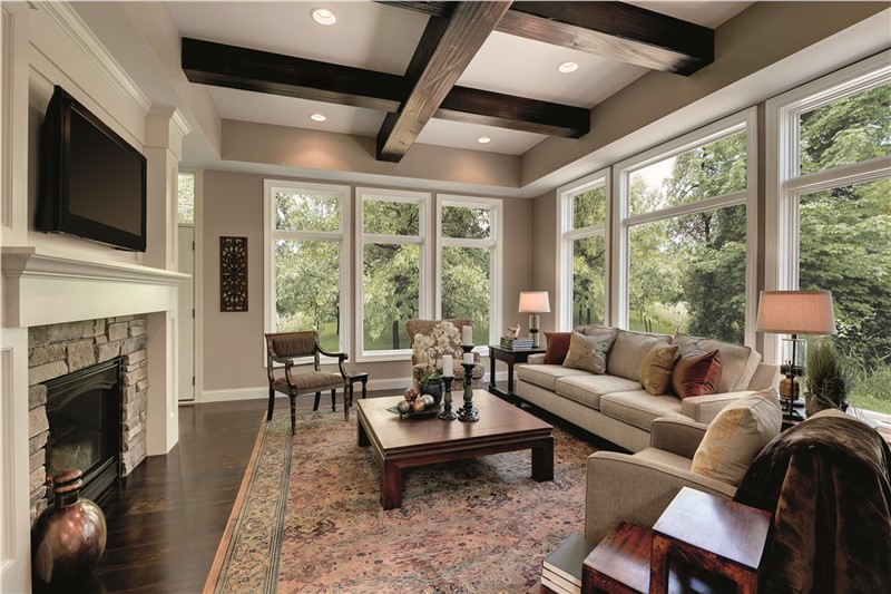 A large decorated living room with tall white windows along the walls.